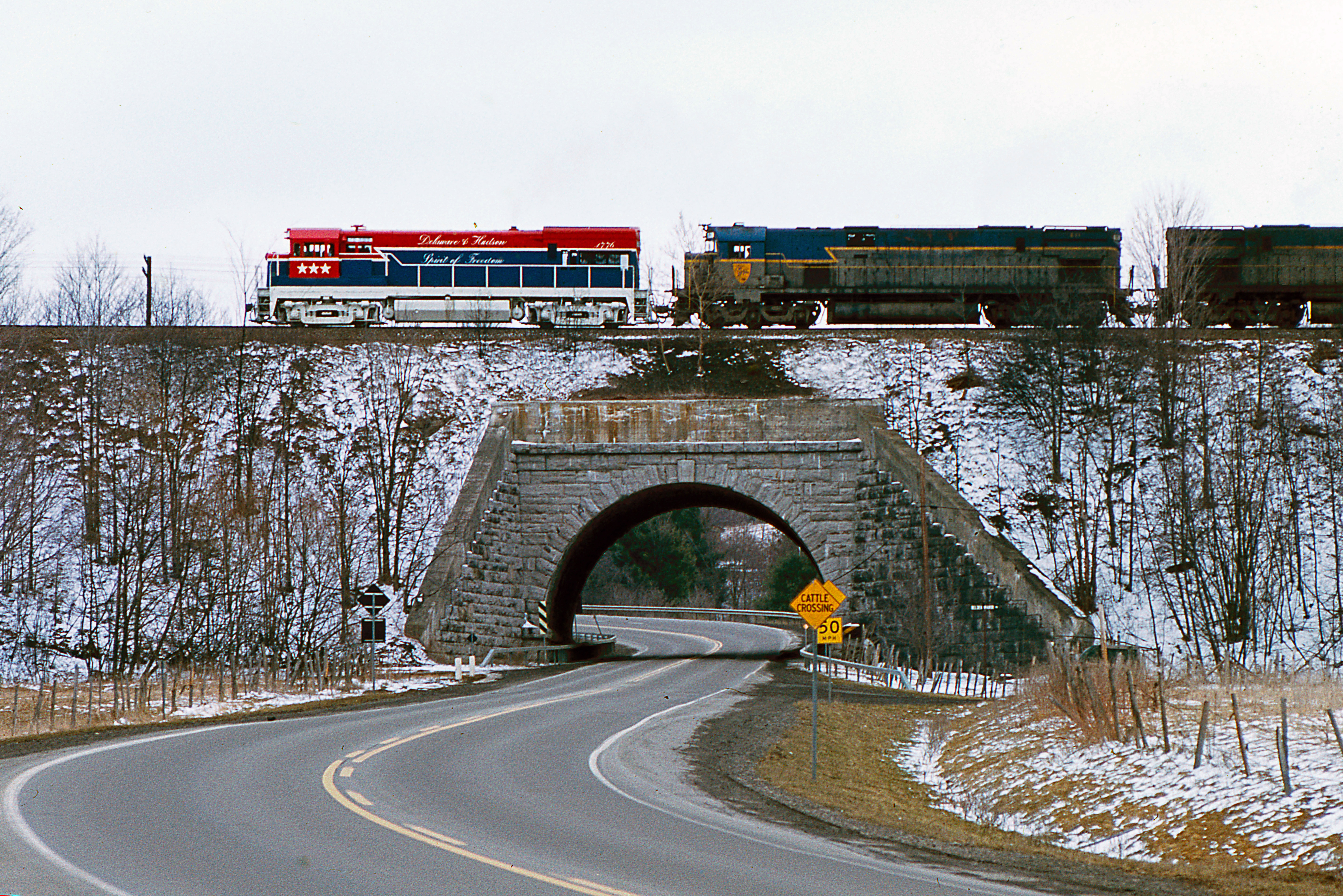 April 8, 1975 D&H #BNW-4 with 1776-611-618 crossing Rt. 7 at FH Cabin Belden Manor, N.Y.